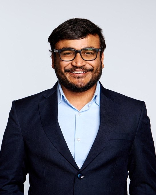 Saketh Saridena, smiling, in a navy blazer and light blue shirt.